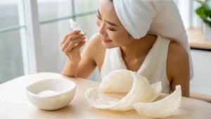 Wanita dengan handuk di kepala melihat serum sarang walet.